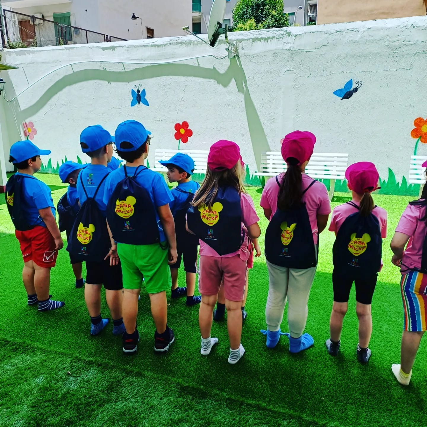 Foto-gruppo-bimbi-centro-estivo-con-zainetti-e-cappellini